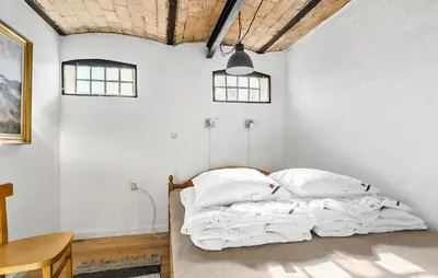 a bed in a room with white walls and windows at Pet Friendly Apartment In Vestervig in Vestervig