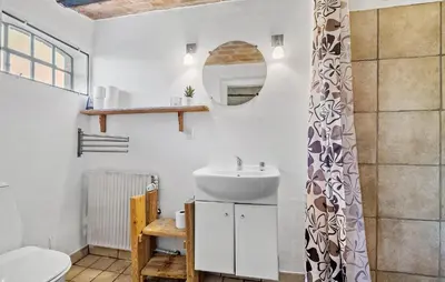 a bathroom with a sink and a toilet and a mirror at Pet Friendly Apartment In Vestervig in Vestervig