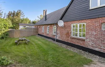 a red brick building with a picnic table in the yard at Pet Friendly Apartment In Vestervig in Vestervig