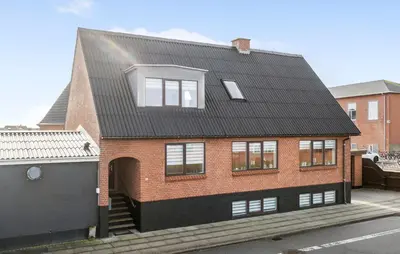 a red brick house with a black roof at 1 Bedroom Nice Apartment In Thyborøn in Thyborøn