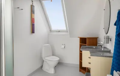 a bathroom with a toilet and a sink and a window at 1 Bedroom Nice Apartment In Thyborøn in Thyborøn