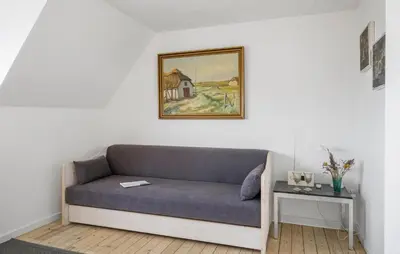 a couch in a room with a picture on the wall at 1 Bedroom Nice Apartment In Thyborøn in Thyborøn