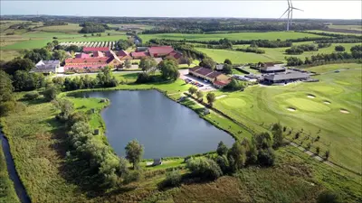 an aerial view of a golf course with a pond at Volstrup Ferieboliger in Stenild