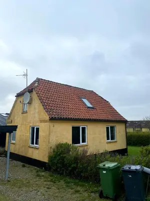 a house with a red roof and two trash cans at Volstrup Ferieboliger in Stenild