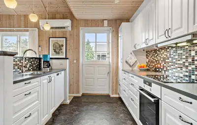 a kitchen with white cabinets and black counter tops at 3 Bedroom Pet Friendly Home In Højslev in Højslev