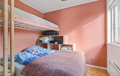 a bedroom with orange walls and a bunk bed at 3 Bedroom Awesome Home In Vestervig in Vestervig