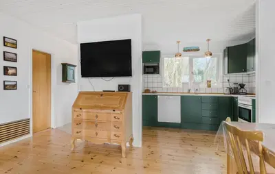 a kitchen with green cabinets and a flat screen tv at 3 Bedroom Awesome Home In Vestervig in Vestervig