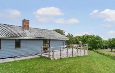 a white house with a wooden deck in front of it at 3 Bedroom Stunning Home In Hurup Thy in Doverodde