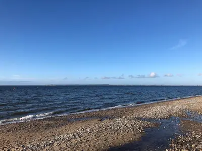 a beach with the ocean on a clear day at 6 person holiday home in Struer-By Traum in Struer