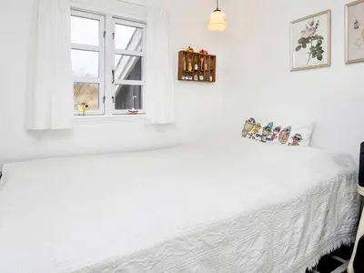 a white bedroom with a white bed and a window at 5 person holiday home in Brovst-By Traum in Brovst