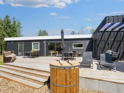 a modern house with a large deck with a barrel at 5 star holiday home in Øster Assels-By Traum in Øster Assels