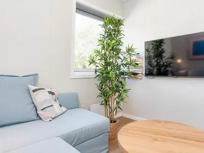 a living room with a blue couch and a table at 5 star holiday home in Øster Assels-By Traum in Øster Assels