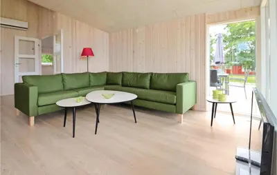 a living room with a green couch and two tables at Holiday Home Hjerm Gh-1983 in Hjerm