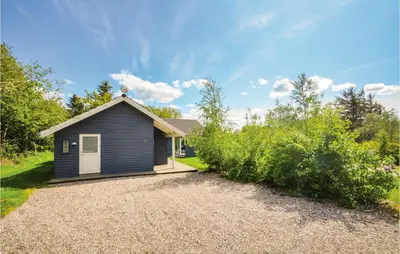 a small blue house with a gravel driveway at Holiday Home Hjerm Gh-1983 in Hjerm