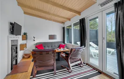 a living room with a table and chairs and a couch at Holiday Home Hurup Thy Ij-1982 in Sønder Ydby