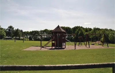 a park with a playground with two swings at Holiday Home Farsø Op-1966 in Farsø