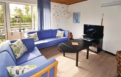 a living room with a blue couch and a piano at Holiday Home Farsø Op-1966 in Farsø