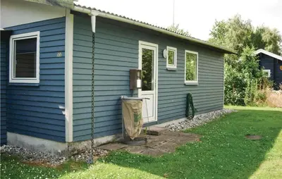 a blue house with a trash can outside of it at Holiday Home Farsø Op-1966 in Farsø