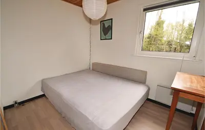 a small bedroom with a bed and a window at Holiday Home Farsø Op-1966 in Farsø