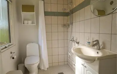 a bathroom with a toilet and a sink at Holiday Home Farsø Qr-1965 in Farsø
