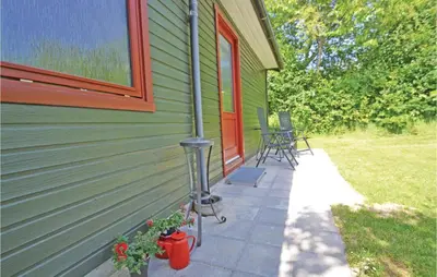 a porch of a green house with a patio at Holiday Home Farsø Qr-1965 in Farsø