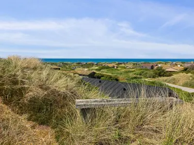 a bench on a hill with the ocean in the background at Holiday Home Kristiina - 500m from the sea by Interhome in Saltum