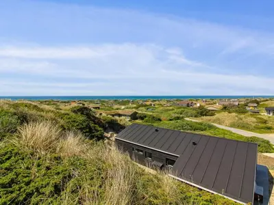 a house on a hill with the ocean in the background at Holiday Home Kristiina - 500m from the sea by Interhome in Saltum