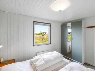 a bedroom with a bed and a window at Holiday Home Pinja - 400m from the sea by Interhome in Løkken