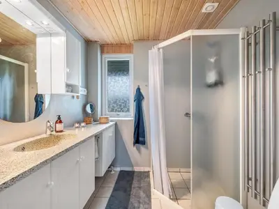 a bathroom with two sinks and a shower at Holiday Home Moreen - 200m to the fjord by Interhome in Vemb