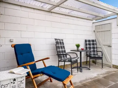 a patio with three chairs and a table at Holiday Home Moreen - 200m to the fjord by Interhome in Vemb