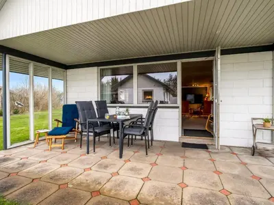 a patio with a table and chairs on it at Holiday Home Moreen - 200m to the fjord by Interhome in Vemb