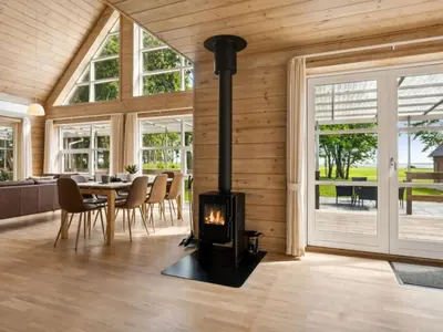a fireplace in a living room with a table and chairs at Holiday Home Månviva - 150m to the fjord by Interhome in Redsted