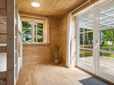 a room with wooden walls and a large window at Holiday Home Månviva - 150m to the fjord by Interhome in Redsted