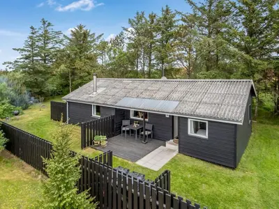 a black tiny house with a deck at Holiday Home Jukka - 2km from the sea by Interhome in Snedsted