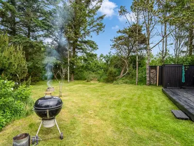 a bbq grill in a grassy yard at Holiday Home Jukka - 2km from the sea by Interhome in Snedsted