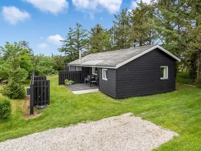 a small black shed in a yard with a patio at Holiday Home Jukka - 2km from the sea by Interhome in Snedsted