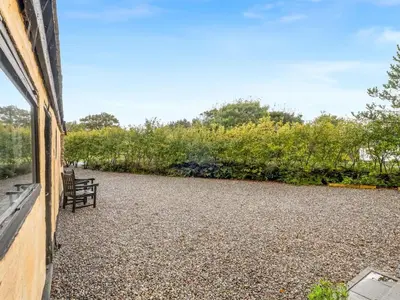 a patio with a bench next to a building at Holiday Home Birtir - 750m from the sea by Interhome in Hanstholm