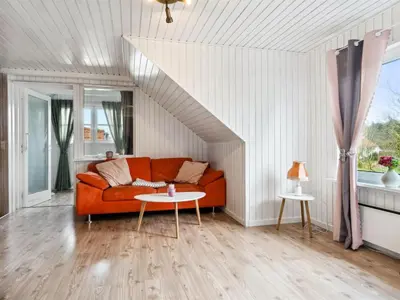 a living room with a couch and a table at Holiday Home Elara - 300m from the sea by Interhome in Thyholm