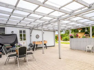 a pergola with a ping pong table and chairs at Holiday Home Elara - 300m from the sea by Interhome in Thyholm