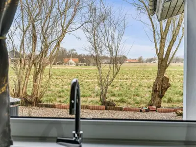 a kitchen window with a view of a field at Holiday Home Elara - 300m from the sea by Interhome in Thyholm