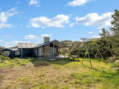 a house on a hill with a playground at Holiday Home Selenia - 1km from the sea by Interhome in Saltum