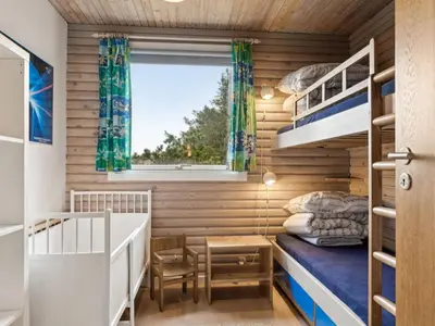 a small bedroom with bunk beds and a window at Holiday Home Selenia - 1km from the sea by Interhome in Saltum