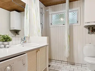 a bathroom with a sink and a toilet at Holiday Home Swenki - 700m from the sea by Interhome in Saltum