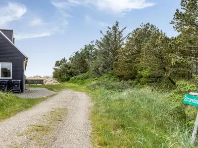 a dirt road next to a house at Holiday Home Ajvi - 900m from the sea by Interhome in Blokhus