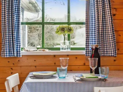 a table with plates and glasses and a window at Holiday Home Bonde - 800m to the fjord by Interhome in Farsø