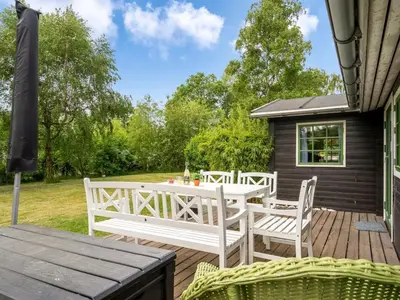 a wooden deck with a table and chairs at Holiday Home Bonde - 800m to the fjord by Interhome in Farsø
