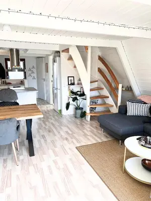 a living room with a couch and a staircase at Hyggeligt golfhus i Himmerland in Farsø