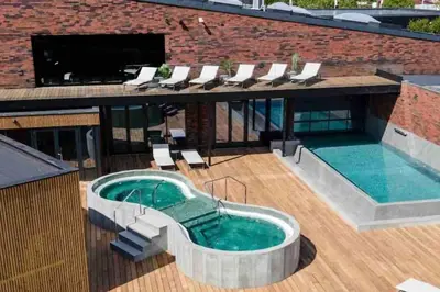 a pool on the roof of a building with chairs around it at Hyggeligt golfhus i Himmerland in Farsø