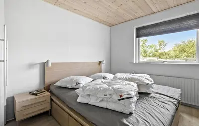 a bedroom with a bed with white walls and a window at Lovely Home In Vestervig With Kitchen in Vestervig