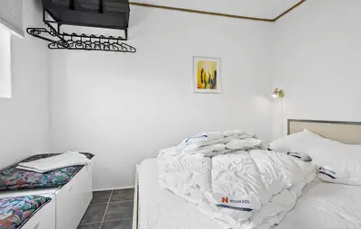 a bedroom with white walls and a white bed and a bedstand at Lovely Home In Vestervig With Kitchen in Vestervig